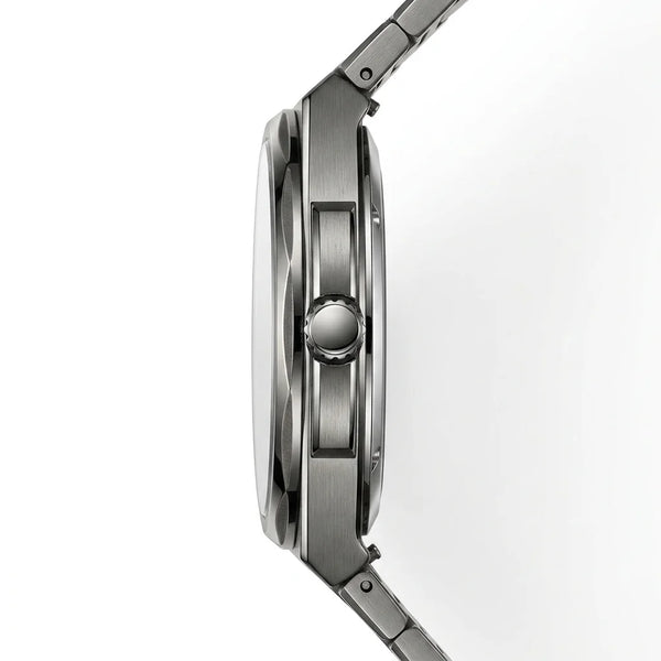 Close-up side profile of a stainless steel watch with a brushed metal case and integrated link band on a white background.