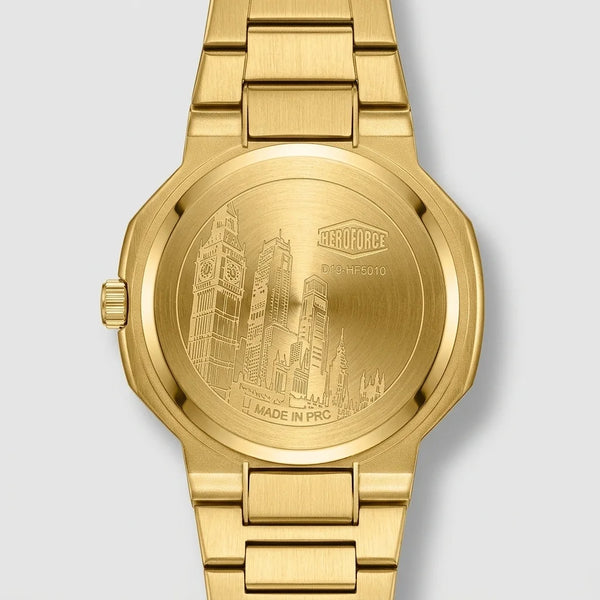 Gold-tone stainless steel watch shown from the back, featuring an engraved cityscape design on the case and a matching metal link bracelet against a light gray background.