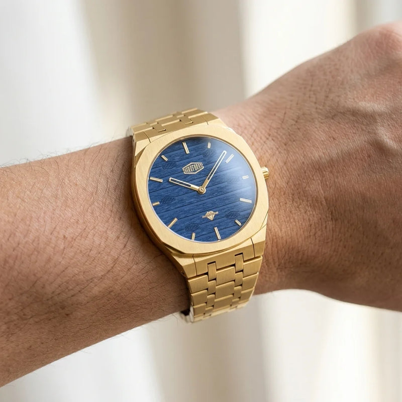gold watch on wrist, blue dial angled