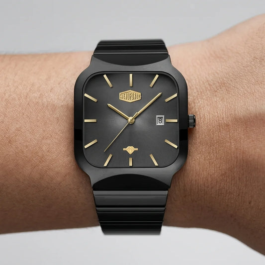 A black rectangular analog watch with gold-tone hands, hour markers, and logo details, shown worn on a person's wrist against a light gray background.