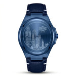 A blue stainless steel wristwatch with a matching blue leather strap, featuring an engraved city skyline design on the dial.
