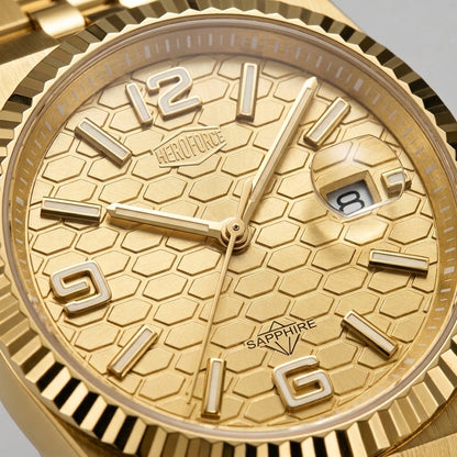 A close-up of a gold-tone wristwatch with a textured dial, fluted bezel, and matching metal link bracelet on a white background.