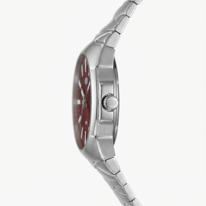 A close-up side profile of a stainless steel watch with a red dial and matching red bezel, featuring a silver metal link bracelet on a light gray background.