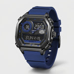A rugged digital watch with a dark gray metallic case, blue strap, and blue/black analog-digital face, shown on a light gray background.