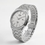 A silver stainless steel wrist watch with a matching link bracelet, featuring a white textured dial, silver hour markers, and a date window at the 3 o'clock position.