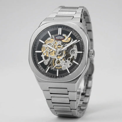 A stainless steel skeleton wristwatch with a black dial, silver-tone case and bracelet, and gold-tone mechanical gears visible through the open-heart design, shown on a light gray background.
