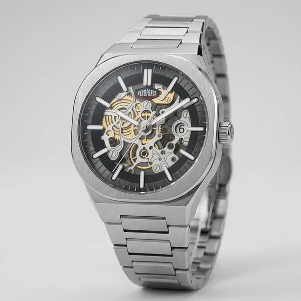 A stainless steel skeleton wristwatch with a black dial, silver-tone case and bracelet, and gold-tone mechanical gears visible through the open-heart design, shown on a light gray background.