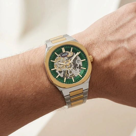 A wristwatch with a green dial and gold-and-silver two-tone metal bracelet, shown worn on a hand
