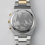 Back view of Round digital wristwatch with alternating silver and gold segmented band, gold bezel, and three gold side buttons