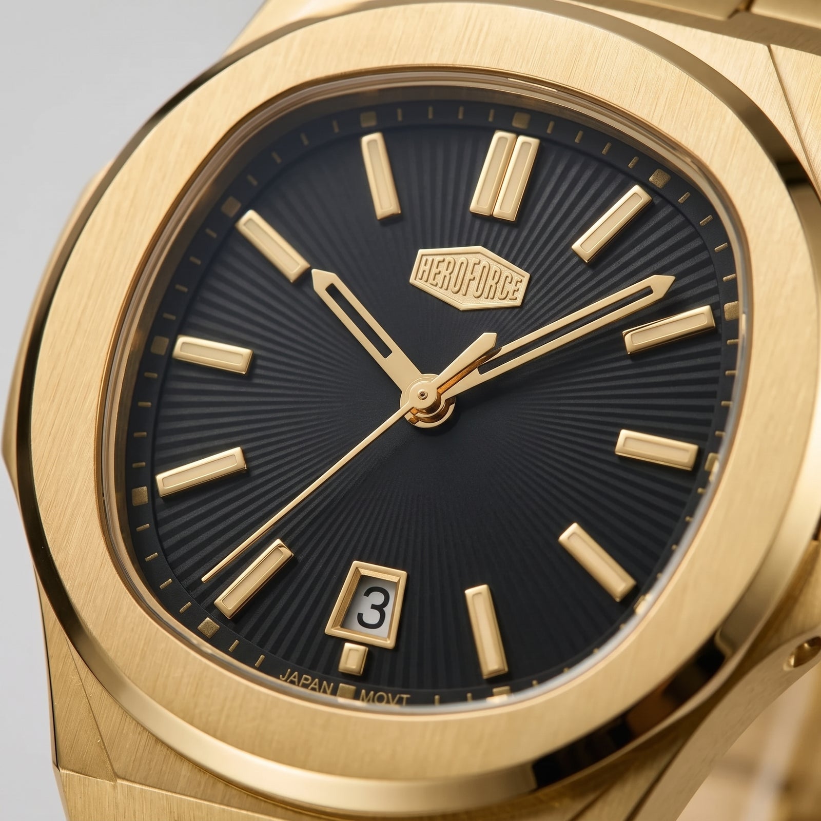 Close-up of a Perodue wristwatch with a brushed gold-toned case, black sunburst dial, gold hour markers and hands, and a date window at the 3 o'clock position.