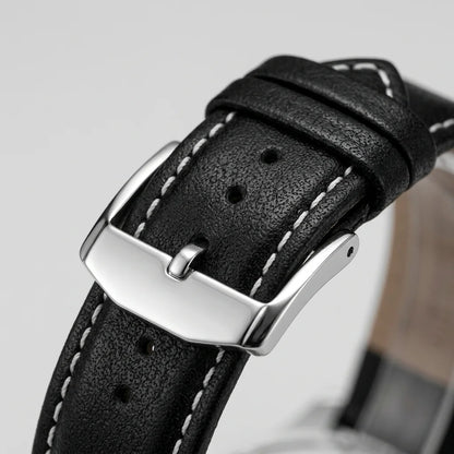 Close-up of a black textured leather watch strap with white contrast stitching and a polished silver-tone metal buckle.