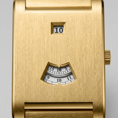 Close-up of a gold-toned wristwatch face with a small digital display showing 10 and an analog minute window below, on a light gray background.