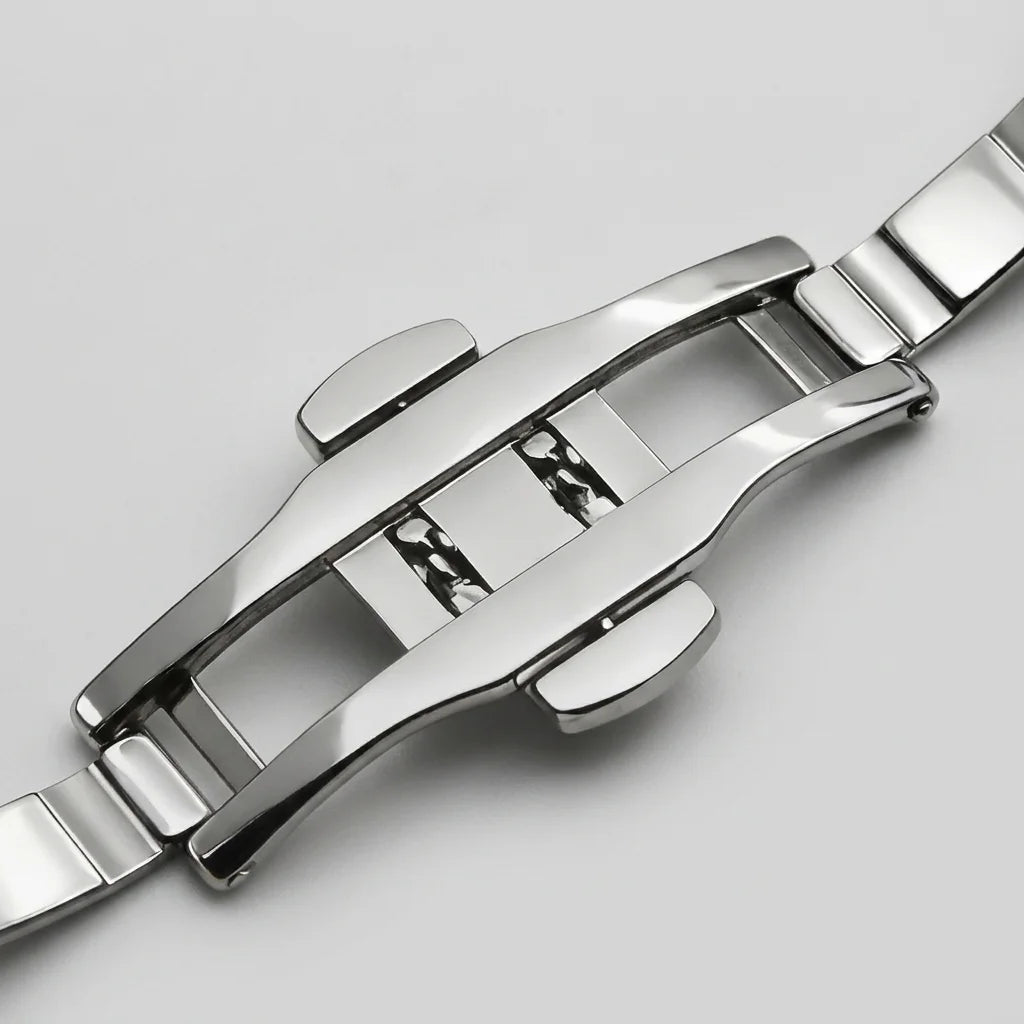 Close-up of a polished stainless steel watch band clasp and adjacent links on a light gray background.