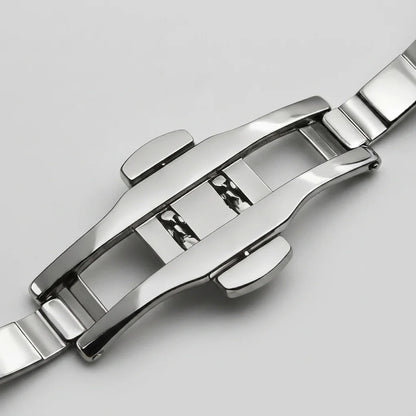 Close-up of a polished stainless steel watch band clasp and adjacent links on a light gray background.