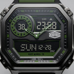 Close-up of a rugged digital watch with a black and dark gray case, green accents, and a black dial displaying time and date details. The brand name HEROFORCE is visible on the watch face.
