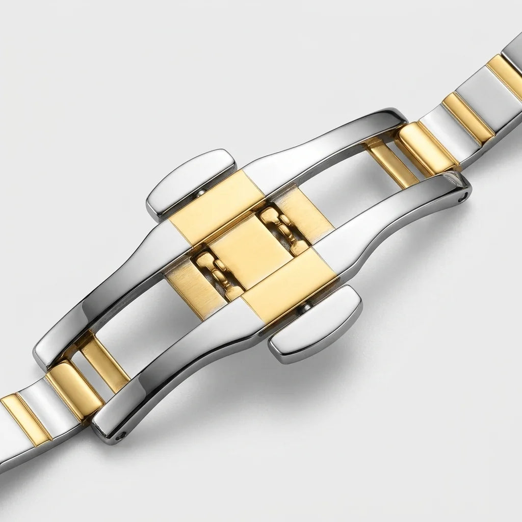 Close-up of a two-tone stainless steel and gold watch band clasp on a light gray background.