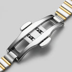 Close-up of a two-tone stainless steel watch band clasp with polished silver and gold links, shown on a light gray background.