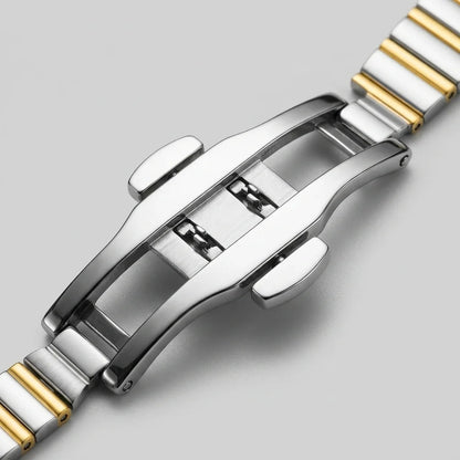 Close-up of a two-tone stainless steel watch band clasp with polished silver and gold links, shown on a light gray background.