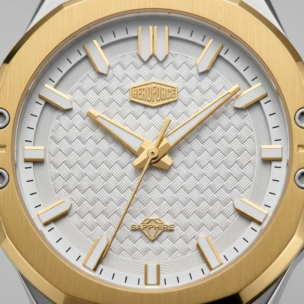 Close-up of men's watch featuring a brushed gold octagonal bezel, a white textured dial with gold hour markers and hands, and a Sapphire crystal.
