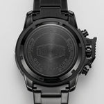 Close-up of the back of a black tactical watch with a metal link band, featuring the brand name 'HEROFORCE' and 'ONE OF A KIND' engraved on the case.