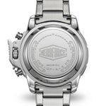 Close-up of the back of a stainless steel wristwatch with a metal link band, showing engraved branding and text on the case back.