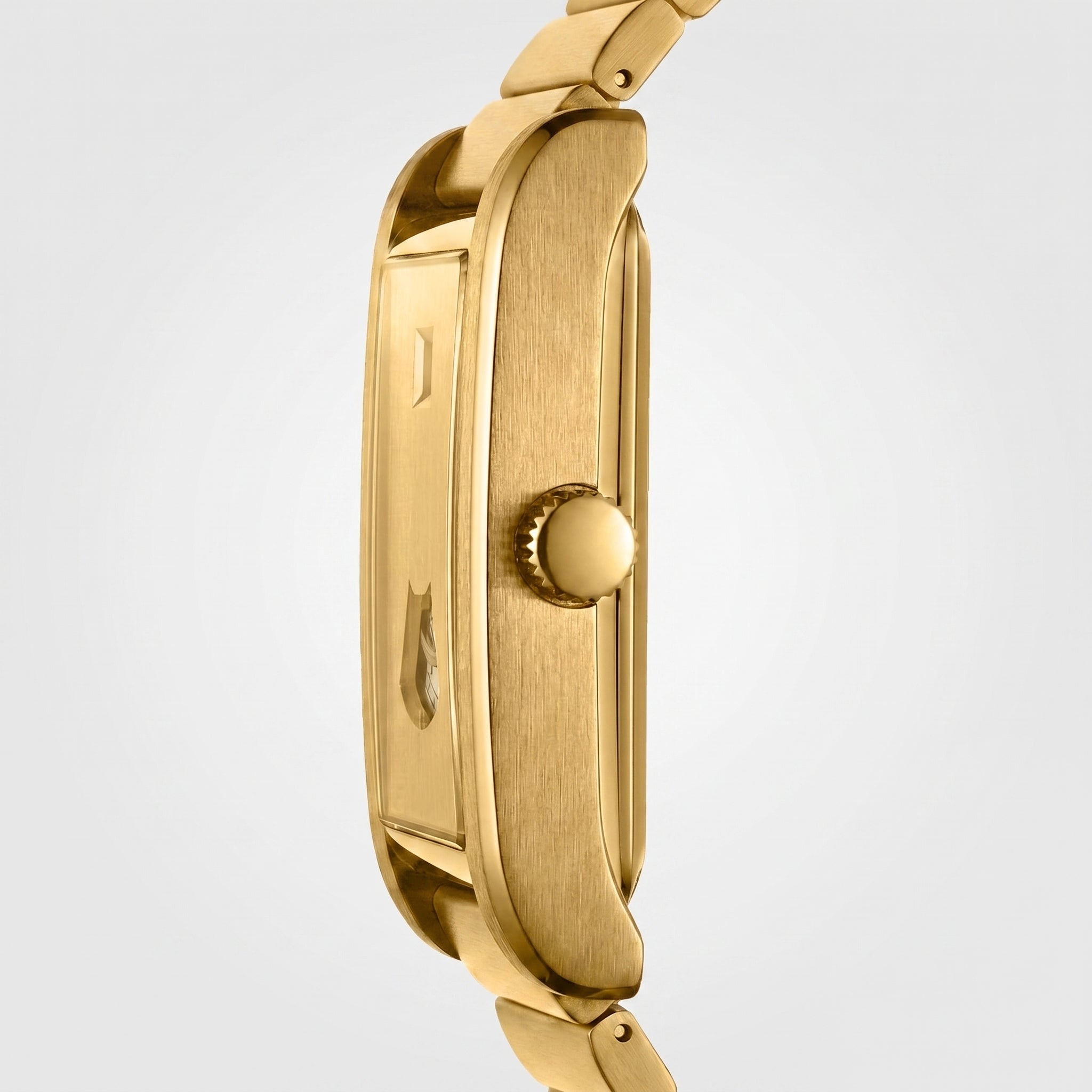 Close-up side view of a gold-tone watch case and matching metal link bracelet on a light gray background.