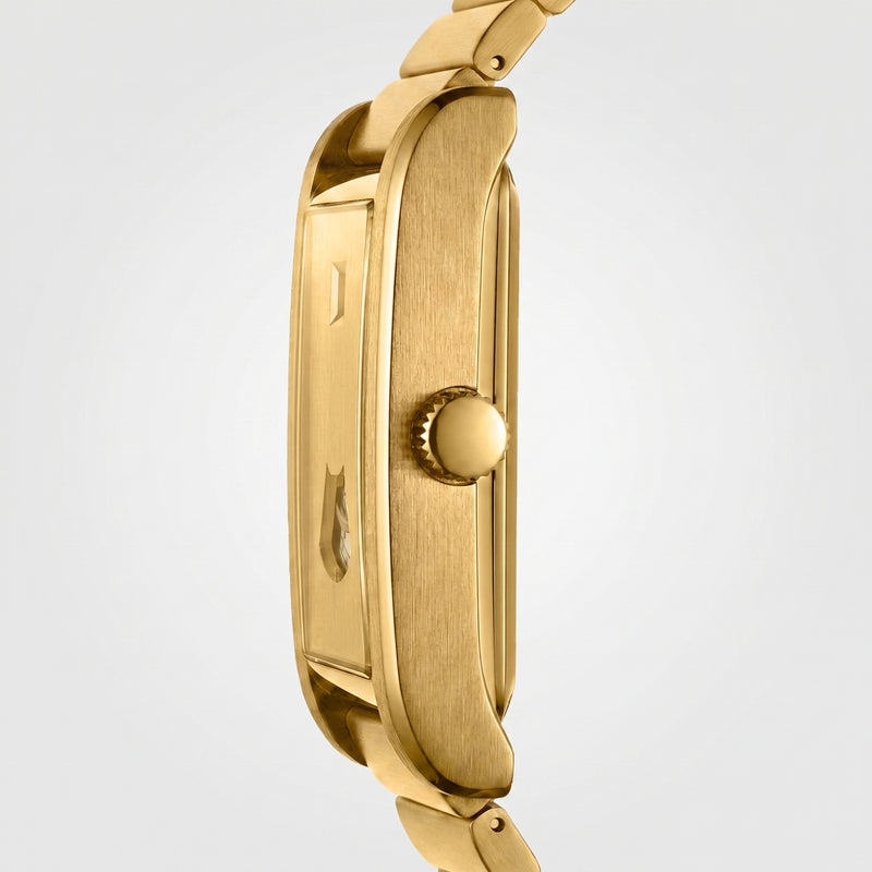 Close-up side view of a gold-tone watch case and matching metal link bracelet on a light gray background.