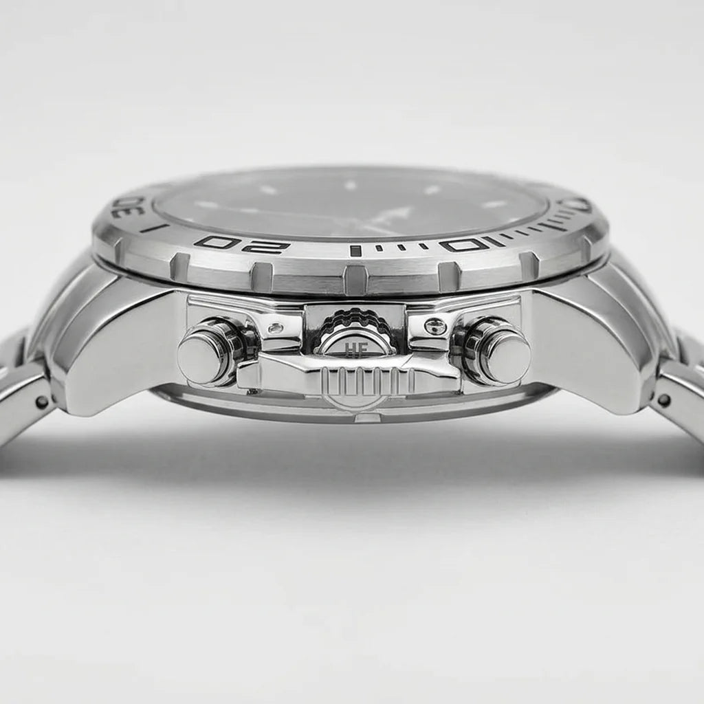 Close-up side view of a stainless steel wristwatch with a silver dial, textured bezel, and matching metal bracelet on a light gray background.
