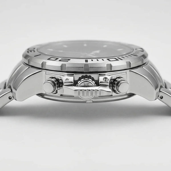 Close-up side view of a stainless steel wristwatch with a silver dial, textured bezel, and matching metal bracelet on a light gray background.