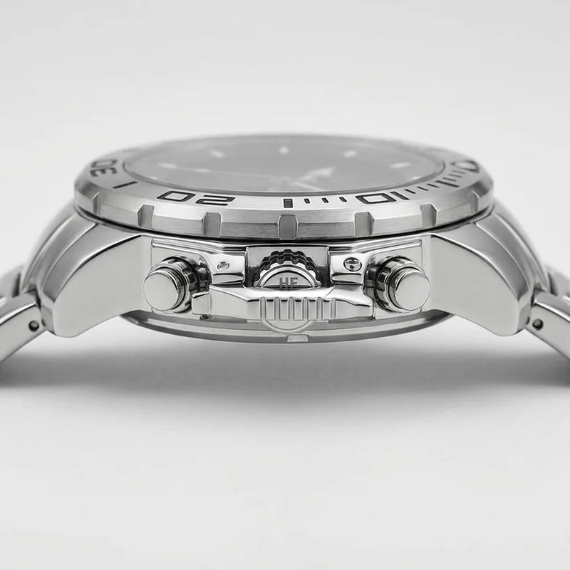 Close-up side view of a stainless steel wristwatch with a silver dial, textured bezel, and matching metal bracelet on a light gray background.