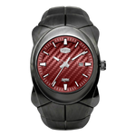 A rugged black watch with a textured red carbon-fiber-style dial, silver-tone hands and markers, and a date window.