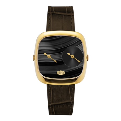 A luxury watch featuring a square cushion-shaped gold-tone case, a black dial with a smaller circular subdial and gold hands, and a dark brown alligator-embossed leather strap.