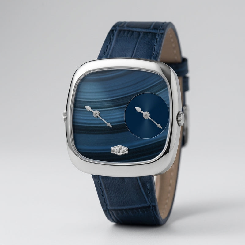 A luxury wristwatch with a silver-toned square bezel, a blue marbled dial featuring a smaller blue sub-dial, and a dark blue leather strap.