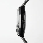 Side profile of Black metallic digital wristwatch with rectangular face and green backlit display