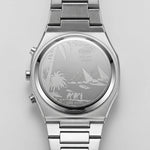 Silver stainless steel wrist watch with a metal link bracelet, featuring an engraved Egyptian desert scene on the back case with pyramids, palm trees, and figures.