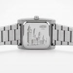 Silver stainless steel wrist watch with a square case and integrated metal link bracelet, shown from the back.