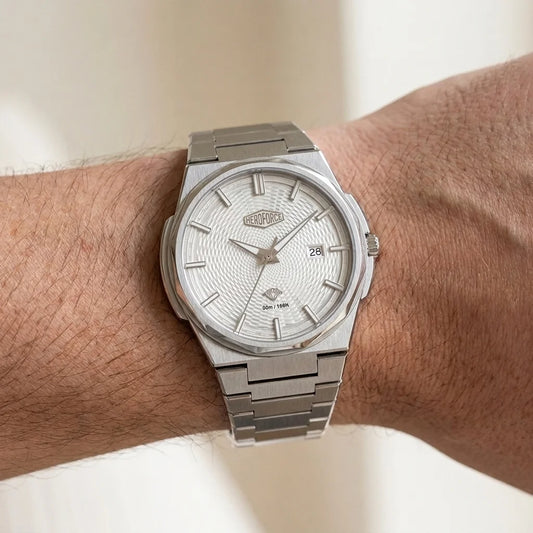 Wrist worn of HEROFORCE wristwatch with silver bracelet, guilloché patterned dial, polished angular bezel, silver markers and hands, date window at 28, brushed steel finish.
