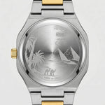 A two-tone stainless steel and gold wristwatch shown from the back, featuring an engraved silver