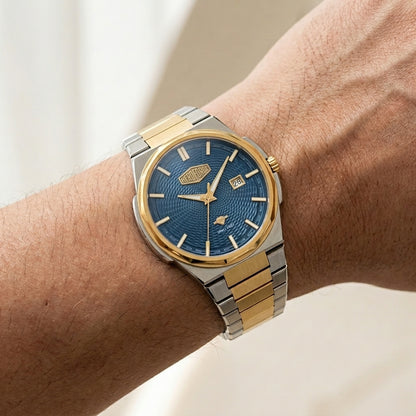 A two-tone wristwatch with a blue sunburst dial and gold and silver metal bracelet, shown worn on a person's wrist.