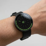 A close-up of a black smartwatch with a black strap worn on a person's wrist.