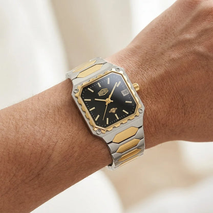 A two-tone stainless steel and gold watch with a black dial, shown worn on a person's wrist.