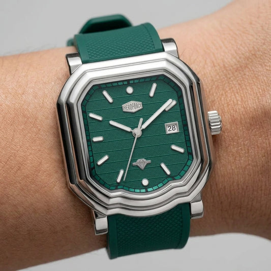 A close-up of a wristwatch with a green textured dial and matching green strap, worn on a person's wrist.